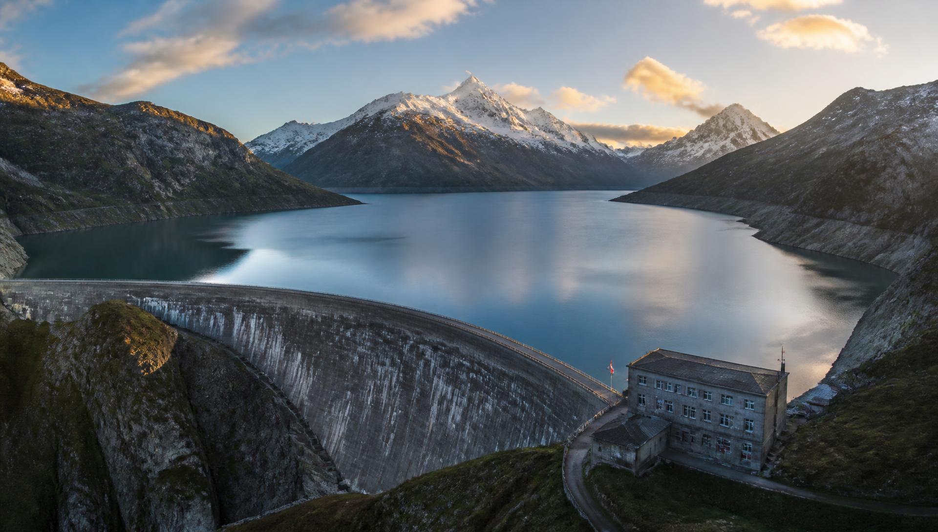 Alpines Wasserkraftwerk mit Staumauer und Speichersee in Österreich